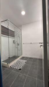 Walk-in glass shower in a fully tiled bathroom