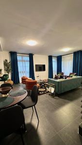 Stylish lounge with green sofa and adjacent dining table