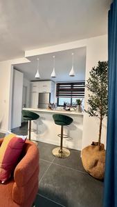 Breakfast bar with gold stools opening onto the kitchen