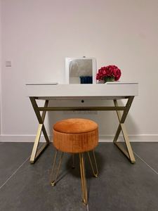 Dressing area with white vanity desk and velvet stool