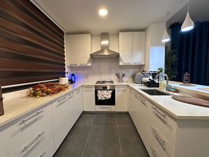 Modern white kitchen with gas range and premium cabinetry