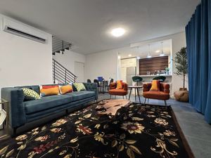 Open-plan living and dining area with blue sofa and statement rug