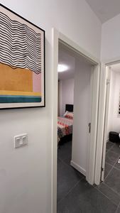Hallway with curated artwork leading to the bedrooms